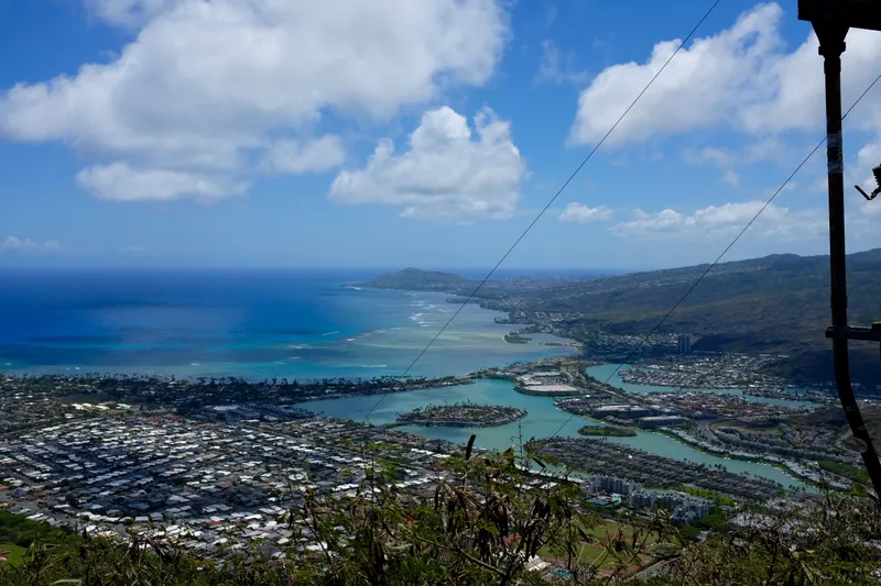 Aerial view of Kailua town, turquoise reef waters, and green ridgelines from a mountaintop on Oahu