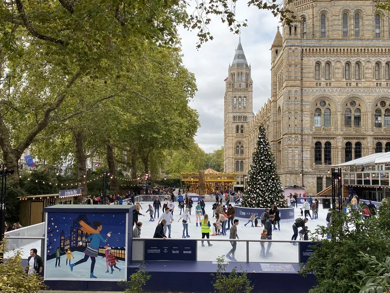 Ice skating rink with a Christmas tree in front of the Natural History Museum in London