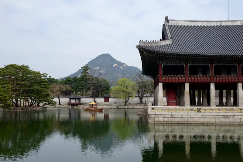 Gyeonghoeru pavilion reflected in a still pond with a mountain rising behind at Gyeongbokgung Palace