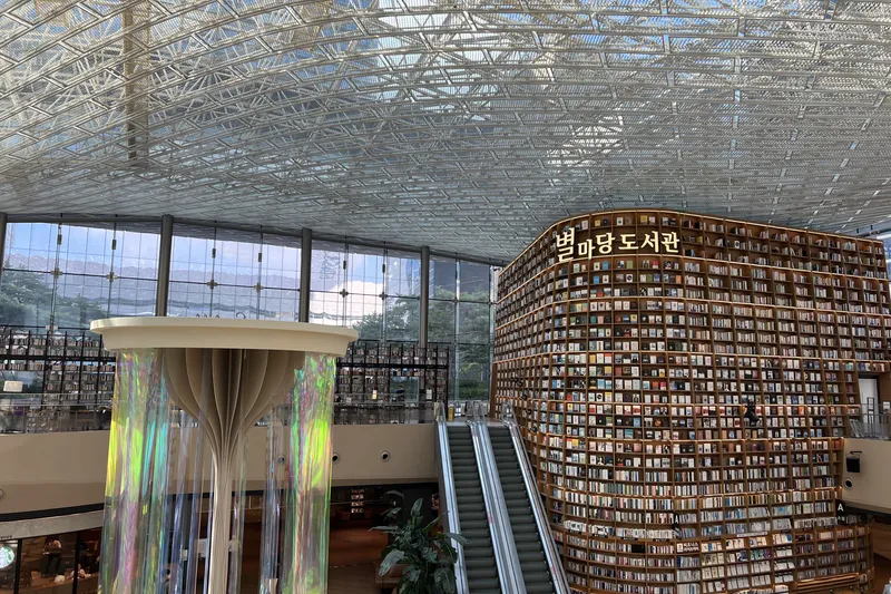 Starfield Library in Seoul with towering floor-to-ceiling bookshelves under a glass lattice ceiling
