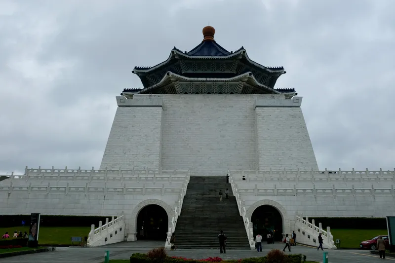 Chiang Kai-shek Memorial Hall in Taipei, a grand white monument with a blue octagonal roof under overcast skies