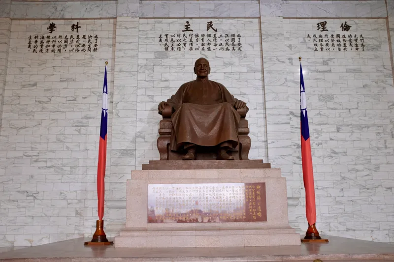 Bronze seated statue of Chiang Kai-shek flanked by Taiwanese flags inside the memorial hall